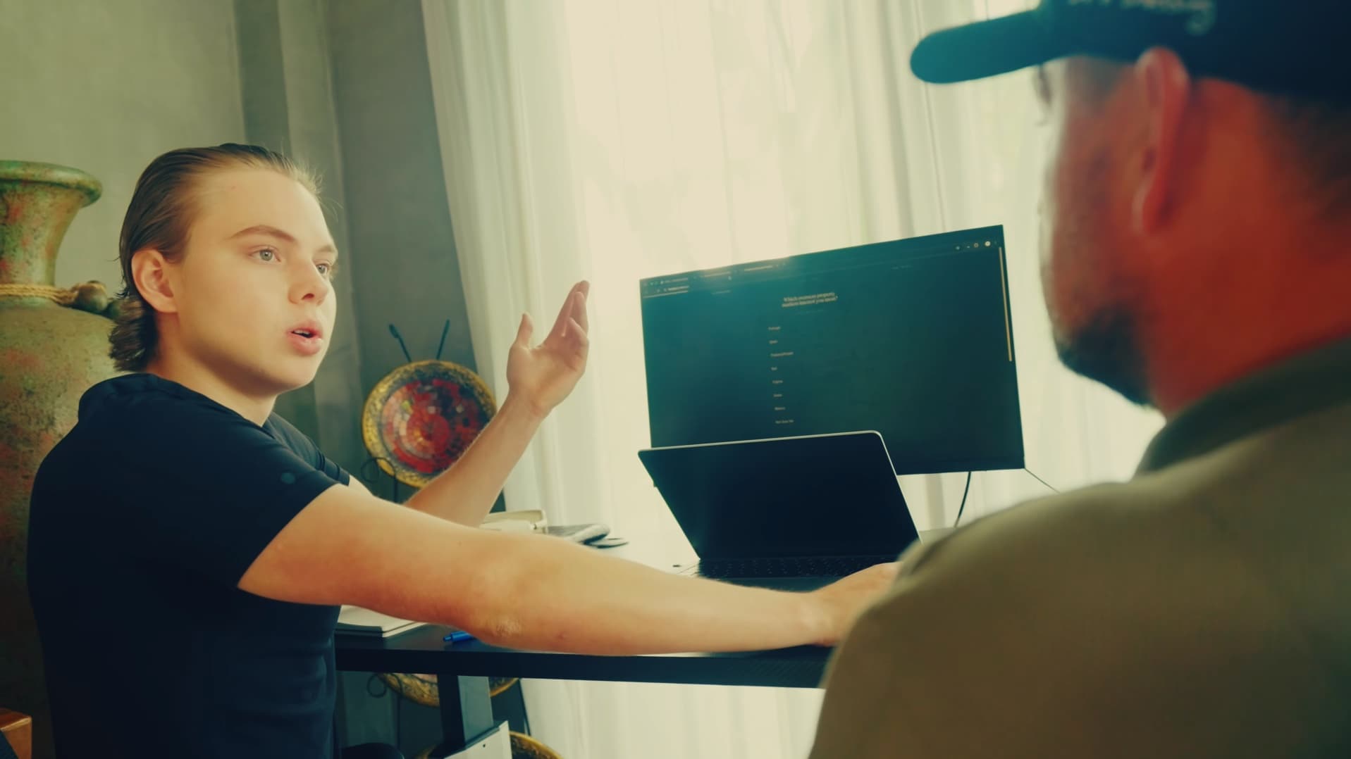 Archie working through a screen with a team member at their desk.