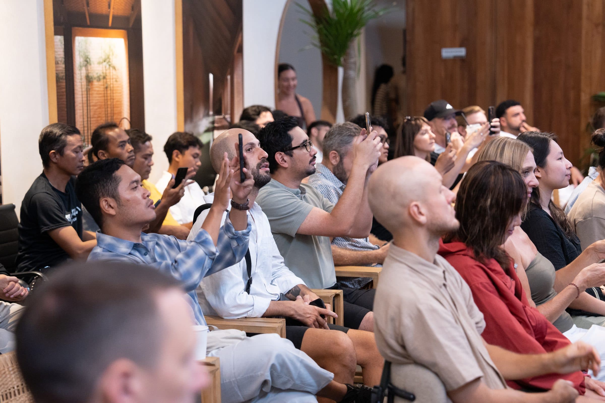The audience at a mastermind session, hands up.